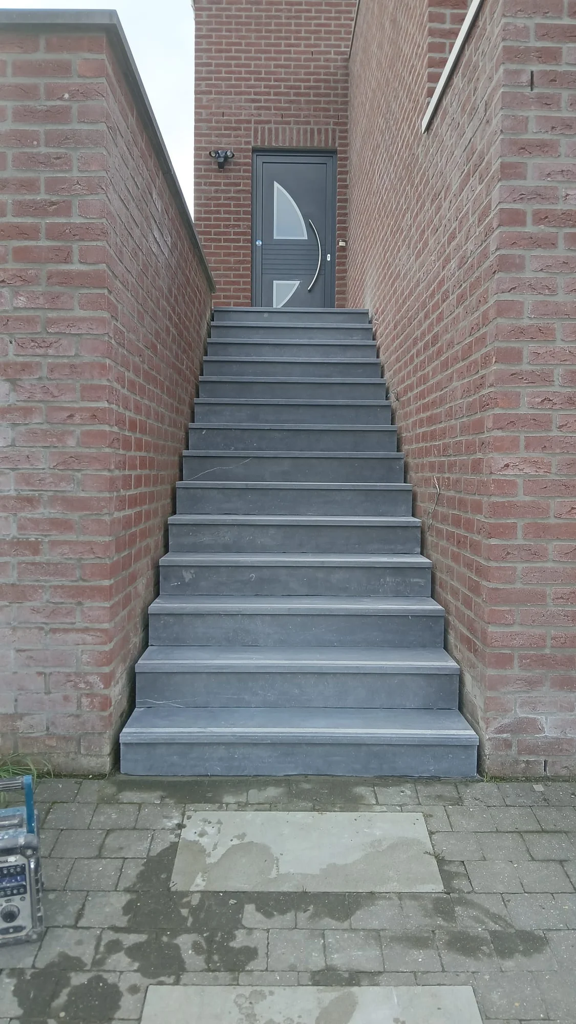 L’escalier extérieur habillé en pierre bleue, vu depuis le bas.